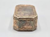 an old silver box sitting on top of a white surface