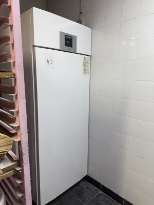 un réfrigérateur blanc dans le coin d'une pièce