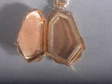 a small gold locke with a chain attached to it