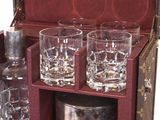 four glasses and a bottle in a case on the table