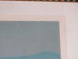 framed photograph of a painting of a beach scene with a blue sky in the background