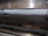 an open oven with a metal grill top in a kitchen
