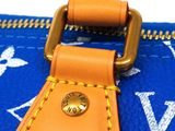 an orange and blue louis vuitton bag with a gold buckle