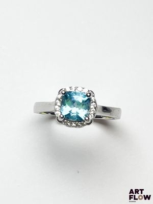 un gros plan d'une bague sertie d'une topaze bleue