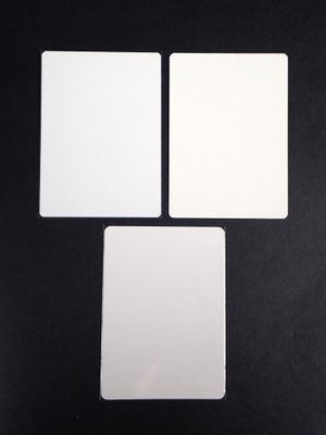 four square white cards sitting on top of a black surface