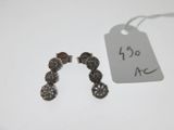 a small pair of earrings that are on a table