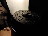 a black object sitting on a table next to a fan