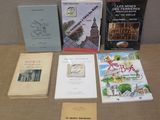 several books are sitting on a table in front of a wall