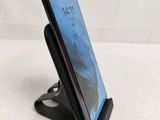 a close up of a cell phone on a stand on a table