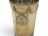 un vase en argent avec une pièce sur le côté