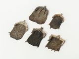five small purses are lined up on a white surface