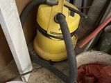 un seau de peinture et un aspirateur par terre