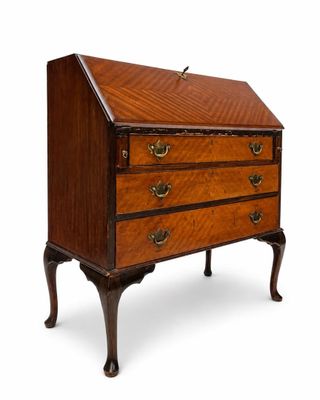 un petit bureau en bois sur pied, muni de tiroirs et de tiroirs