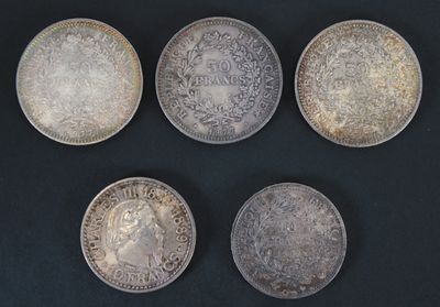 six different types of silver coins on a black surface