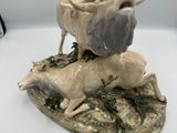 une statue représentant un cerf et une chèvre sur un rocher