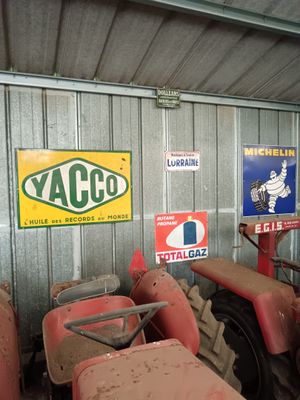 many old tractors in a garage with signs on the wall