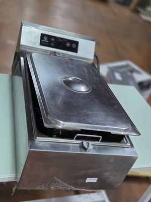 un four en argent posé sur une table dans une pièce