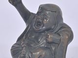 a statue of a man sitting on a chair with his arms up