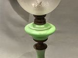 a green lamp with a glass globe on top of it