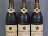 trois bouteilles de vin sont posées sur une table en verre