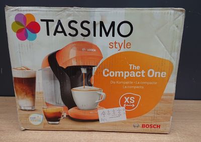 une boîte posée sur une table, sur laquelle se trouve une cafetière