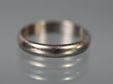 un gros plan d'une bague en argent posée sur une surface réfléchissante