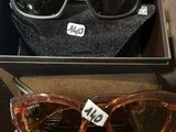 deux paires de lunettes de soleil rangées dans une boîte avec une étiquette de prix