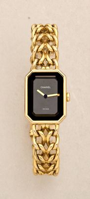 a close up of a gold wrist watch with a black face