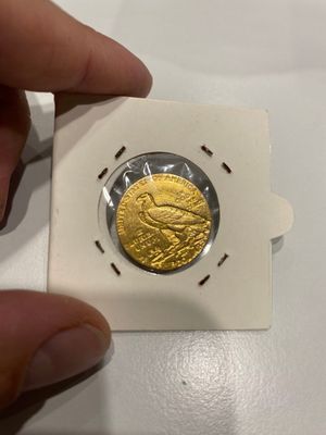 une personne tenant une pièce d'or dans la main