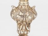 une image représentant un vase en argent posé sur une table