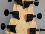 the headstock of an electric guitar with a wooden body