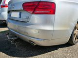 a silver car parked in a parking lot with other cars in the background