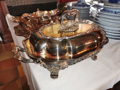 a silver platter on a table with plates and bowls