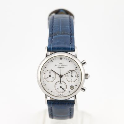 un gros plan d'une montre au cadran blanc et au bracelet en cuir bleu