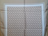 a close up of a white and brown scarf on a table