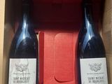 deux bouteilles de vin dans une boîte rouge posée sur une table
