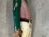 a wooden statue of a man with a hat on a wall