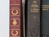several books in a box on a white surface with a few other books
