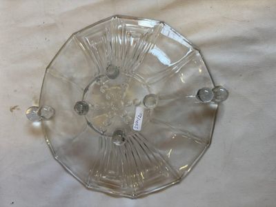 a clear glass plate with a handle on a table