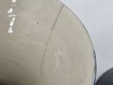 a white bowl with a black lid next to a black bowl