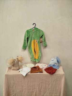 une table sur laquelle sont posés des vêtements et des bonnets pour bébé