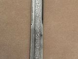a close up of a knife on a table with a brown background