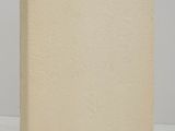 an old book sitting on top of a white table next to a white wall
