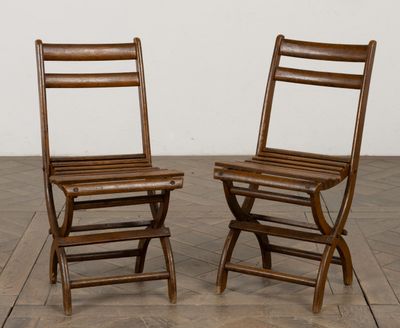 une paire de chaises pliantes en bois posées sur un parquet en bois massif