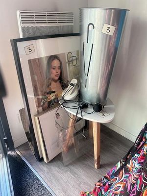 une photo d'une femme assise sur une chaise à côté d'une poubelle