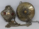 a silver purse with a chain around it on a white surface