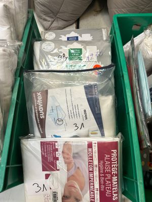 a green box filled with a lot of diapers on top of a bed