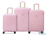 three pieces of pink luggage sitting next to each other on a white surface