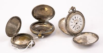 Plusieurs montres de poche anciennes en argent sont posées sur une surface blanche