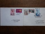 two envelopes with stamps on them sitting on a wooden table